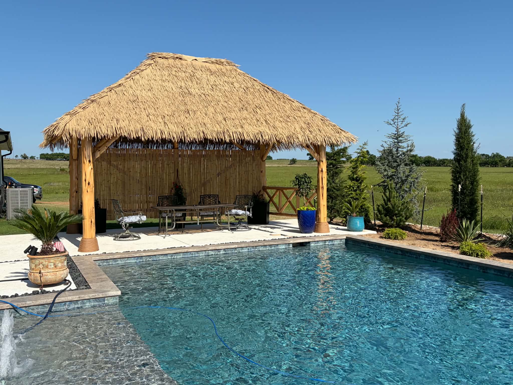 Underside of a finished palapa with cedar beams and hanging chairs