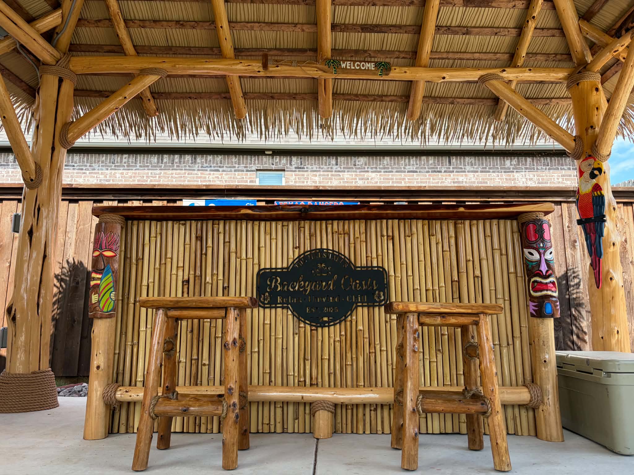 Custom cedar and bamboo tiki bar with stools in a backyard